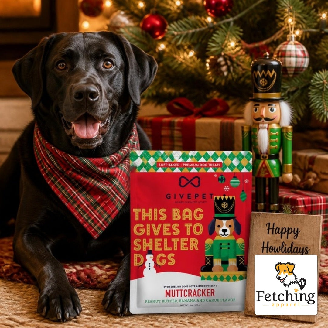 Black Labrador under a Christmas tree with a bag of Muttcracker soft-baked dog treats and a Happy Howlidays sign with the Fetching Apparel logo