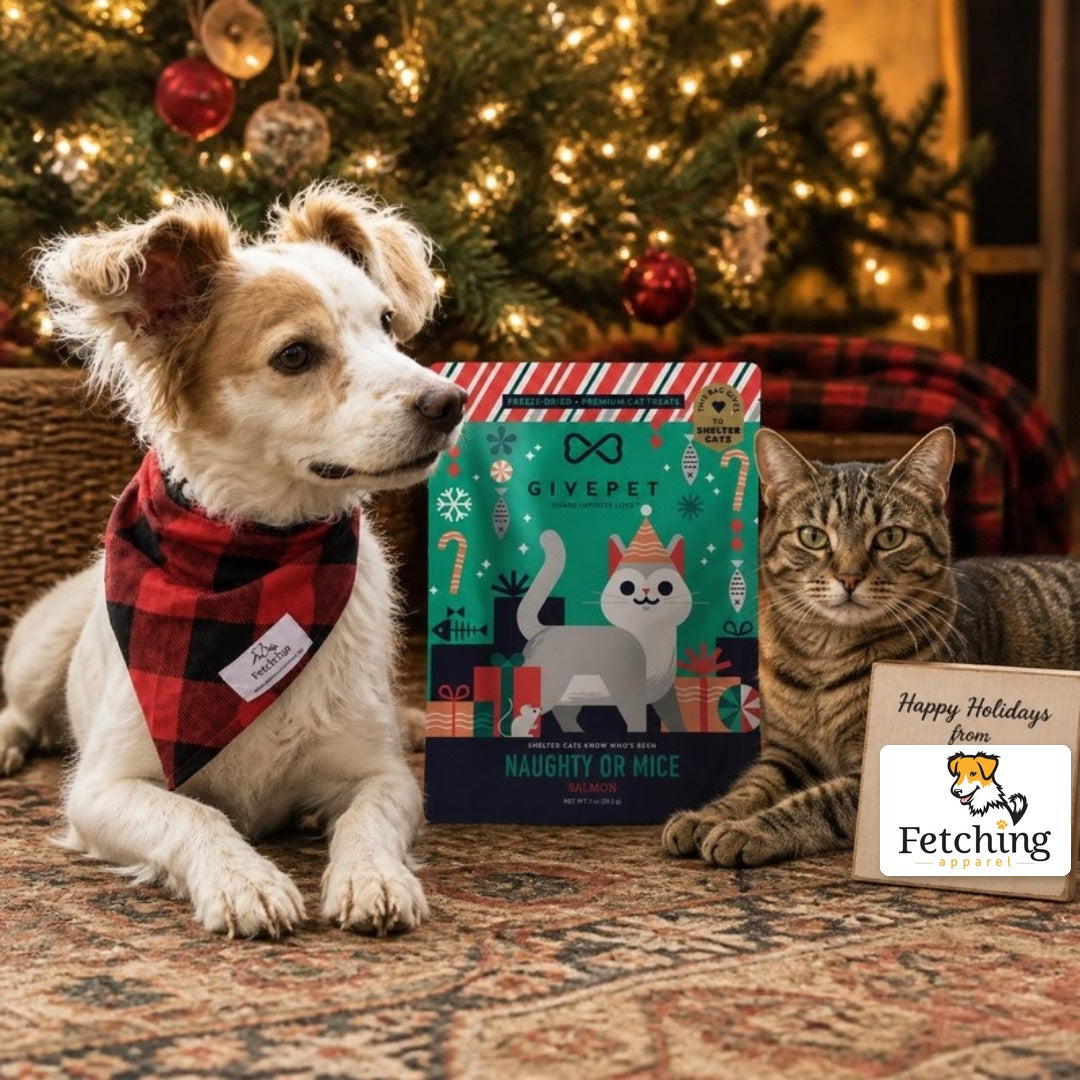 Fetching Apparel's mascot pup with a tabby cat and a bag of Naughty or Mice cat treats by a Christmas tree, with a sign showing the Fetching Apparel logo